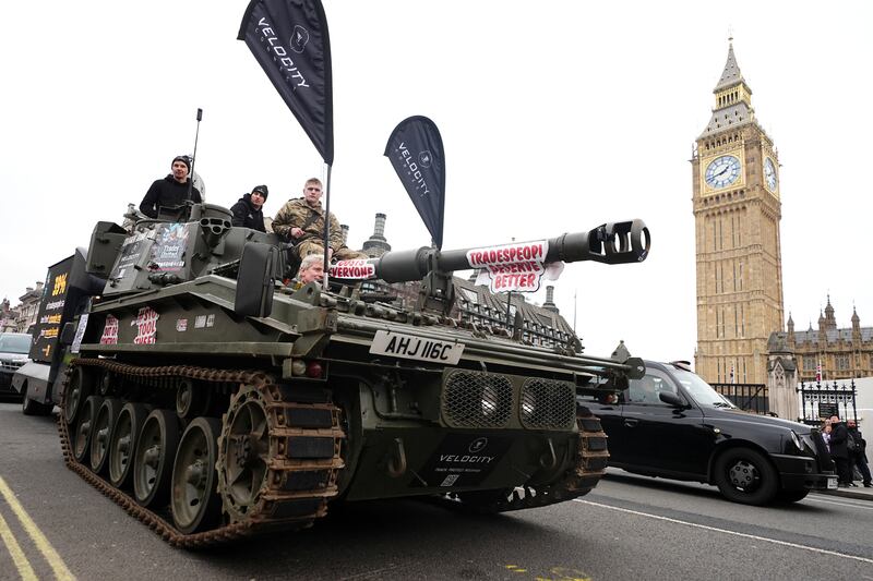 Vehicles take part in a slow drive protest against tool theft in Parliament Square