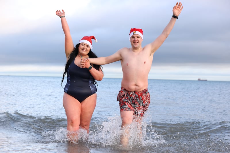 Rebecca Browne and Joel McElwee take part in the annual Christmas Eve swim at Helen’s Bay, Co Down, in aid of local charities