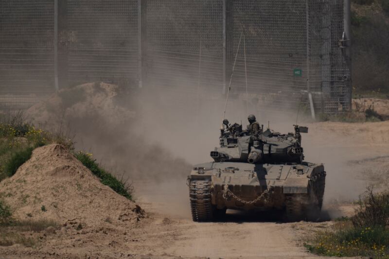 An Israeli soldier moves atop a tank near the Israeli-Gaza border (AP Photo/Leo Correa)