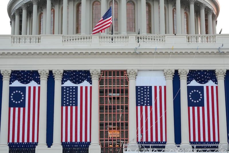 Flags hang in place on the West Front of the US Capitol (Jon Elswick/AP)