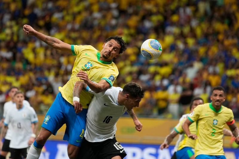 Brazil’s Marquinhos, left, and Uruguay’s Mathias Olivera go for a header (Andre Penner/AP)