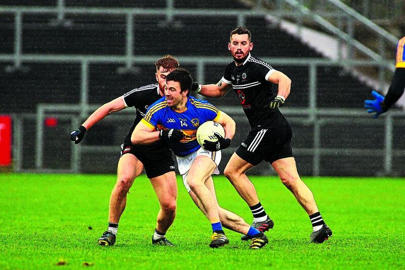  Maghery’s Aidan Forker makes a break through the Kilcoo rearguard