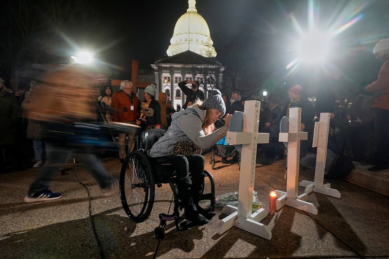 A supporter signs a cross during a candlelight vigil outside the Wisconsin Capitol in Madison (Morry Gash/AP)