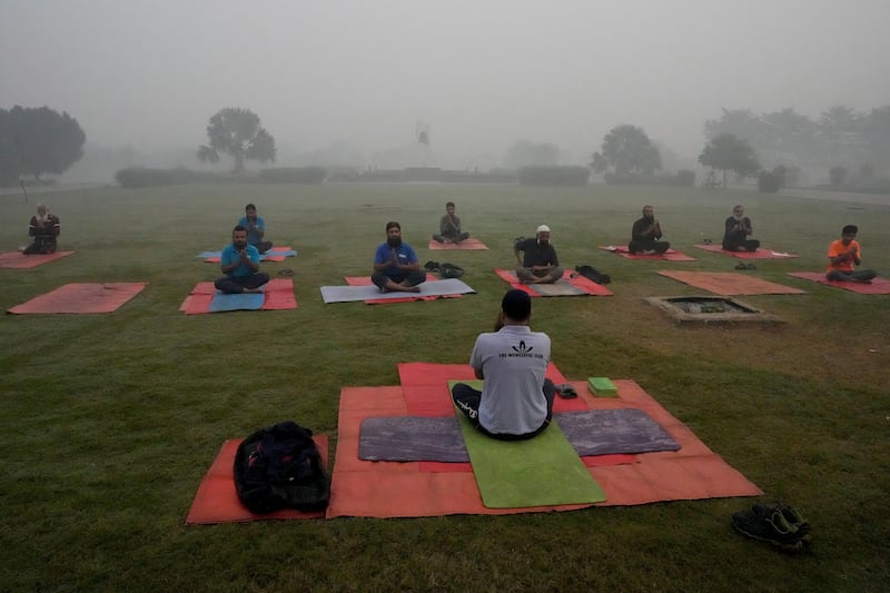 People attend their yoga class as smog envelops the area (KM Chaudary/AP)