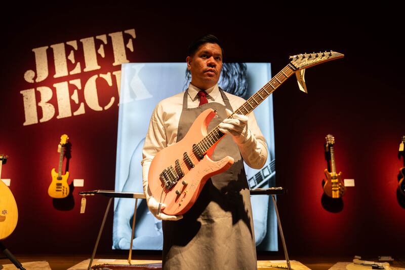 An art handler holds a 1983 Jackson guitar with an engraving made by Tina Turner during the photocall for the Jeff Beck: The Guitar Collection at Christie’s in London