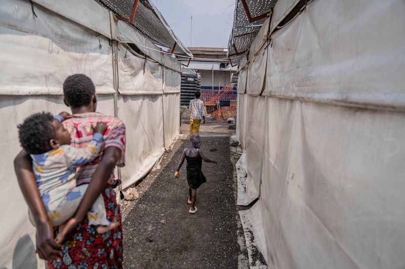 A girl suffering from mpox walks past a treatment centre in Munigi, Democratic Republic of the Congo (Moses Sawasawa/AP)