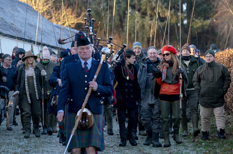 The Perth and District Pipe Band leads a procession including comedian Paul Whitehouse to the River Tay