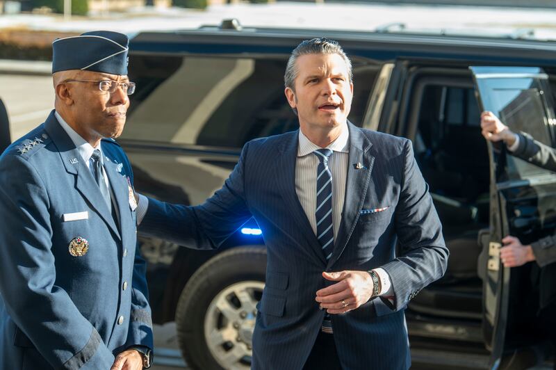 Defence secretary Pete Hegseth, right, pats Chairman of the Joint Chiefs of Staff General Charles Q. Brown Jr on his shoulder as he answers questions from reporters (AP/Kevin Wolf)