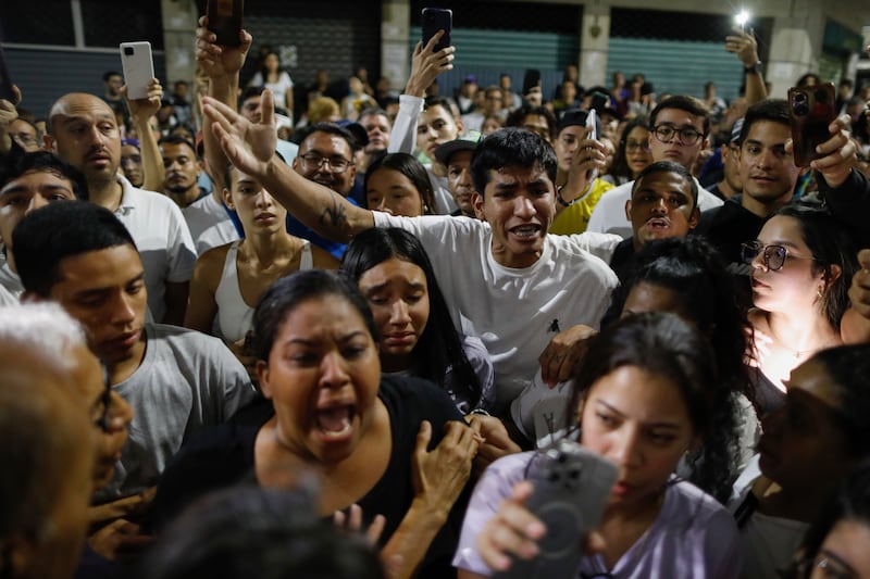 Supporters of opposition candidate Edmundo Gonzalez gather outside the Andres Bello School voting centre asking for the results (Cristian Hernandez/AP)