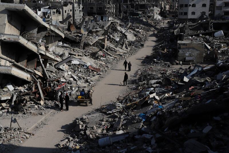 Palestinians walk through the destruction from the Israeli offensive in Jabaliya refugee camp in the Gaza Strip (AP)