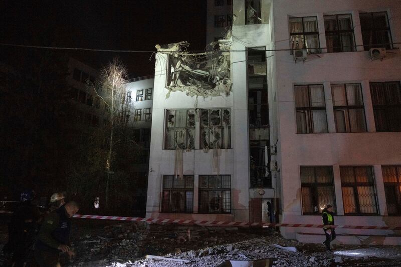 Firefighters inspect a damaged office building after it was hit by Russian aerial guided bombs in central Kharkiv (AP Photo/Efrem Lukatsky)