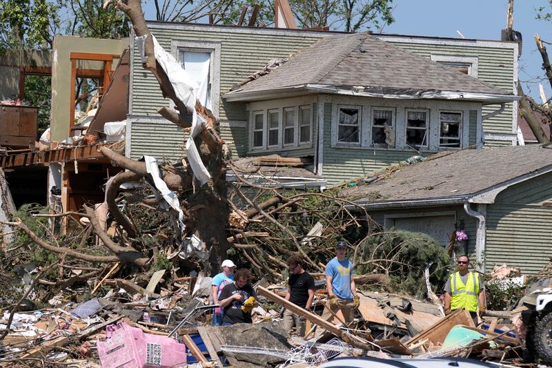 Local residents clean up debris from tornado damaged homes in Greenfield (Charlie Neibergall/AP)