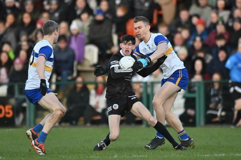 Eugene Branagan of Kilcoo getting away from Ben McDonnell and Tommy Canavan of Errigal Ciarán at the BOX-IT Athletic Grounds in the AIB Ulster Club Senior Football Championship Final