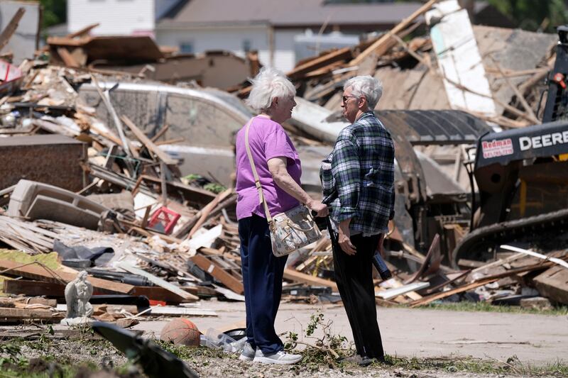 Joan Mitchell, left, talks with her neighbour Edith Schaecher in front of their tornado damaged homes in Greenfield, Iowa (Charlie Neibergall/AP)