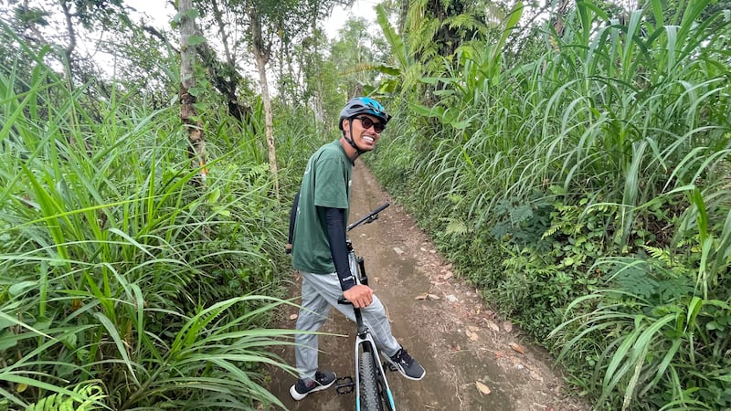 Dewa gives me a gentle downhill cycling tour of village life.