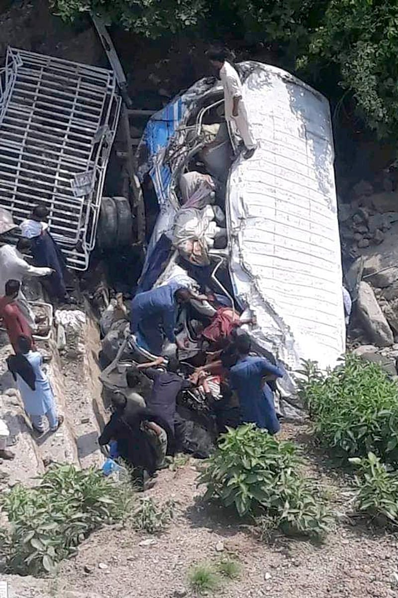 Volunteers recover the bodies and injured passengers from the wreckage of the bus a ravine near Kahuta in Pakistan (AP)