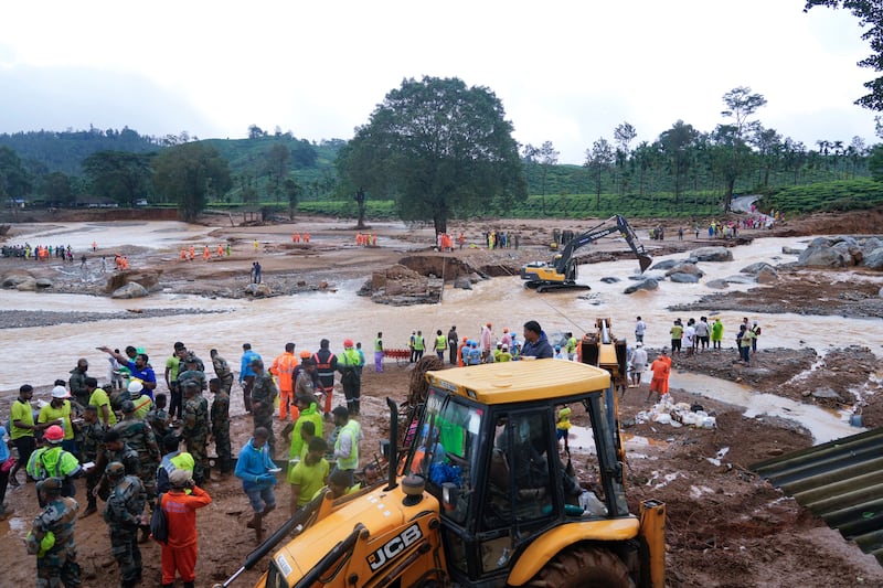 Rescuers use machinery to sift through debris (Rafiq Maqbool/AP)