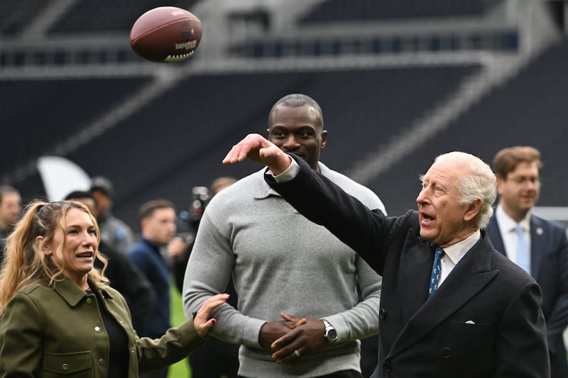 The King was taught how to throw an American football during a visit to Tottenham Hotspur Stadium on Wednesday