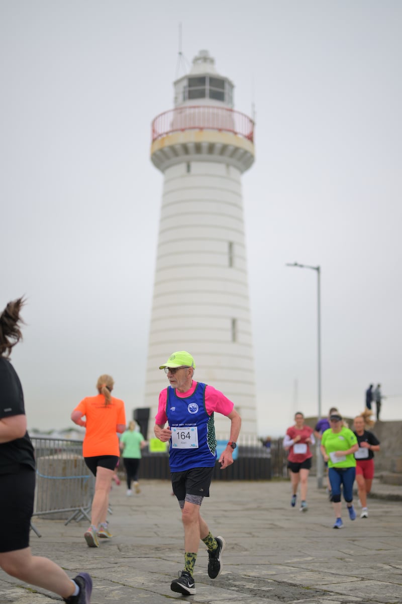 Group of runners in 5k race in front of white lighthouse