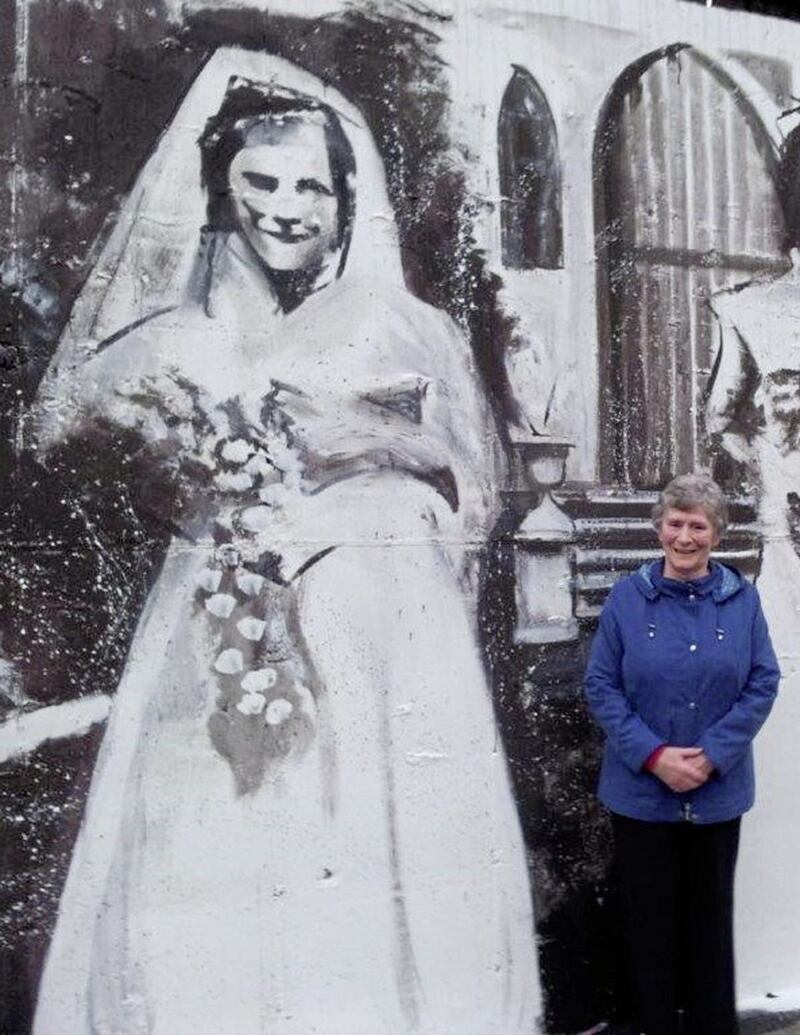 Tilly pictured beside the mural on North Queen Street of her wedding photo 