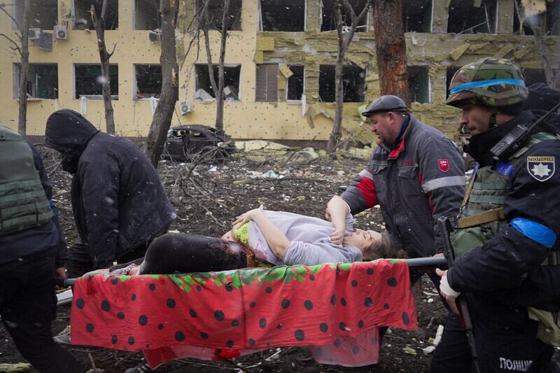 A pregnant woman who later died is taken from a maternity hospital after it was bombed by Russian forces