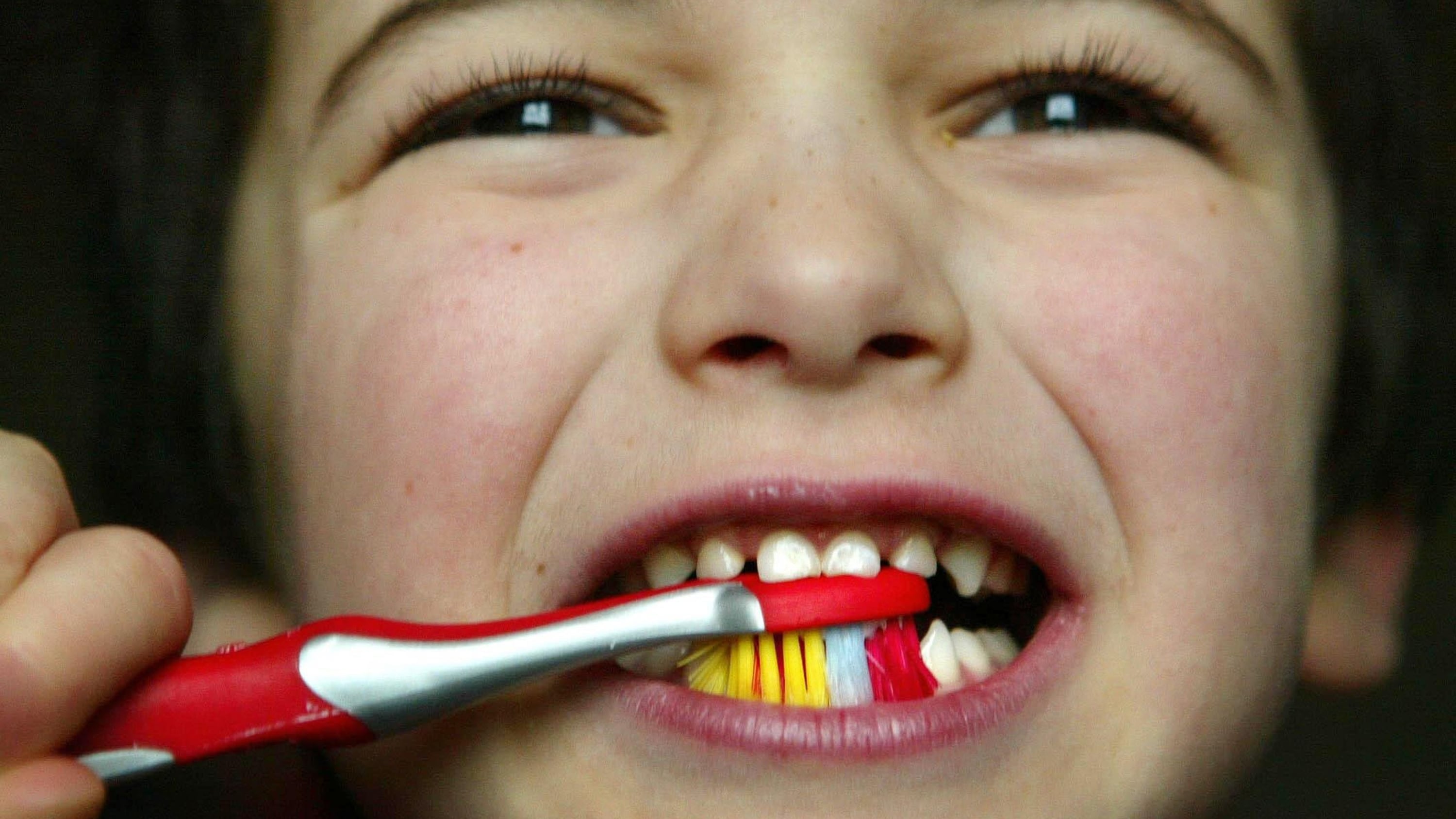 A young child brushing his teeth