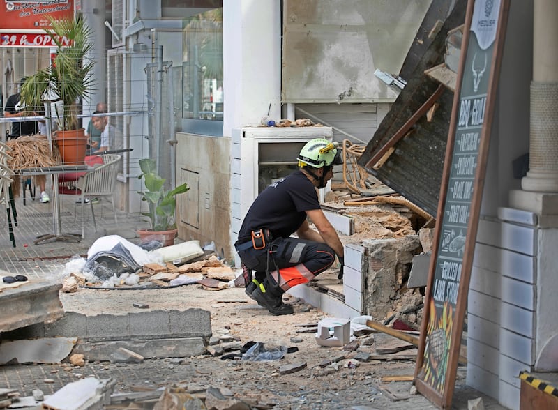 A firefighter looks at part of a collapsed building in Palma de Majorca, Spain (Francisco Ubilla/AP)