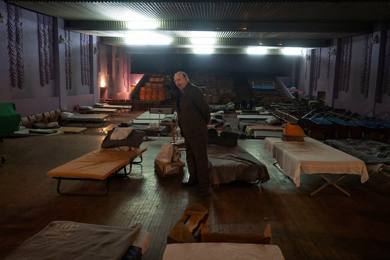 A man waits for evacuation to western Ukraine as he stands by a bed in a city theatre that hosts refugees fleeing from Russian offensive in the Donetsk region (Efrem Lukatsky/AP)