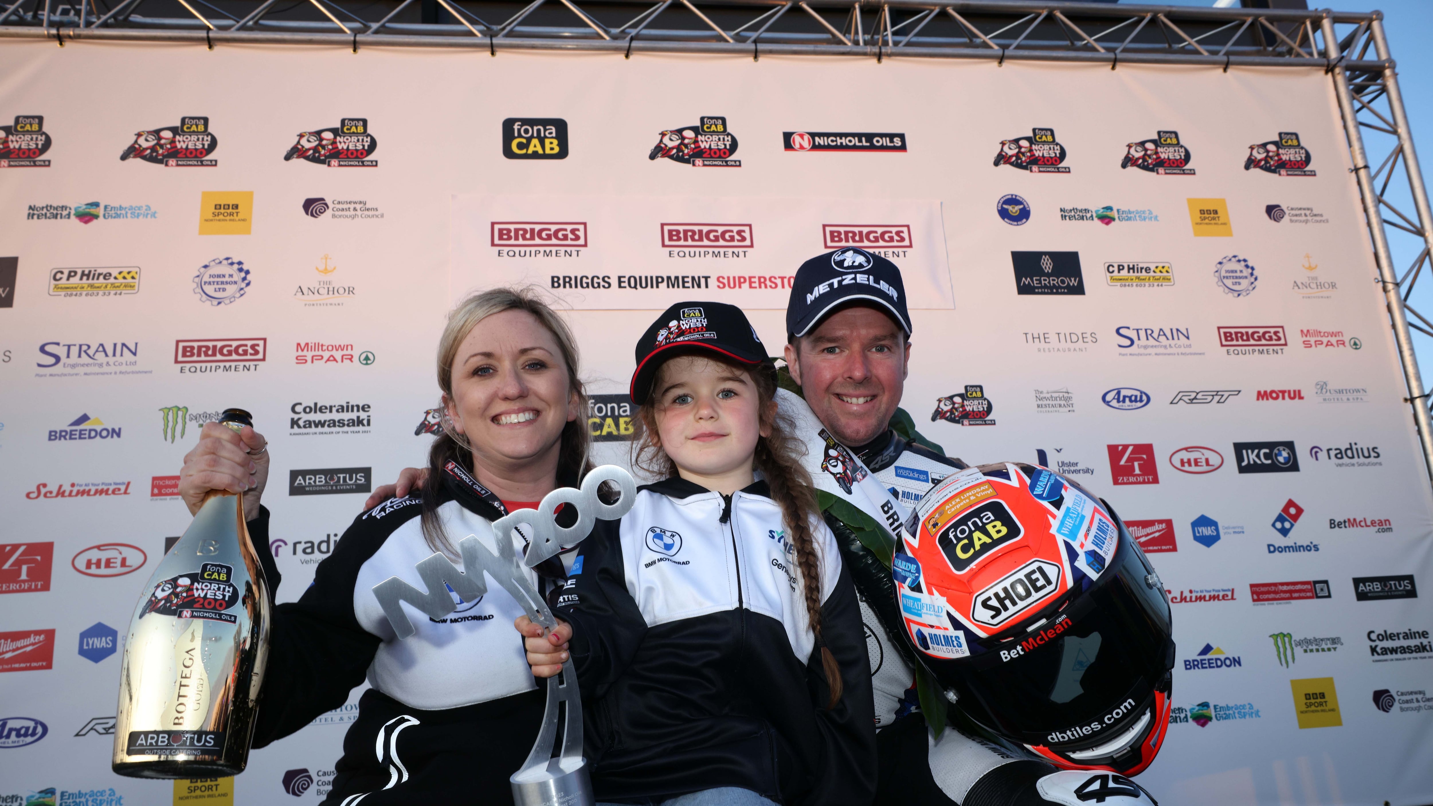 Alastair Seeley celebrates on the podium with his wife Danni and daughter Olivia after victory in the Briggs Equipment Superstock race at the NW200 on Thursday evening