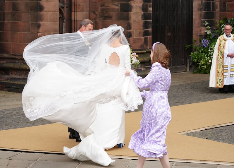 Olivia Henson’s dress billows in the wind upon arriving at Chester Cathedral for her wedding to Hugh Grosvenor, the Duke of Westminster